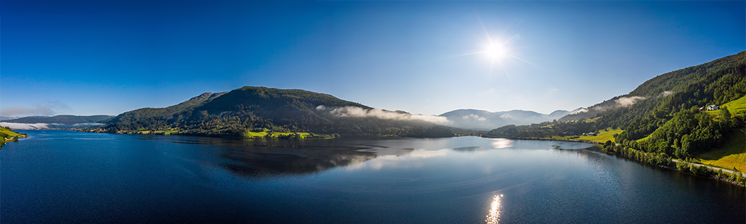 Lac paisible entouré de montagnes sous un ciel lumineux, symbole de sérénité, d’équilibre intérieur et de clarté dans la prise de décision