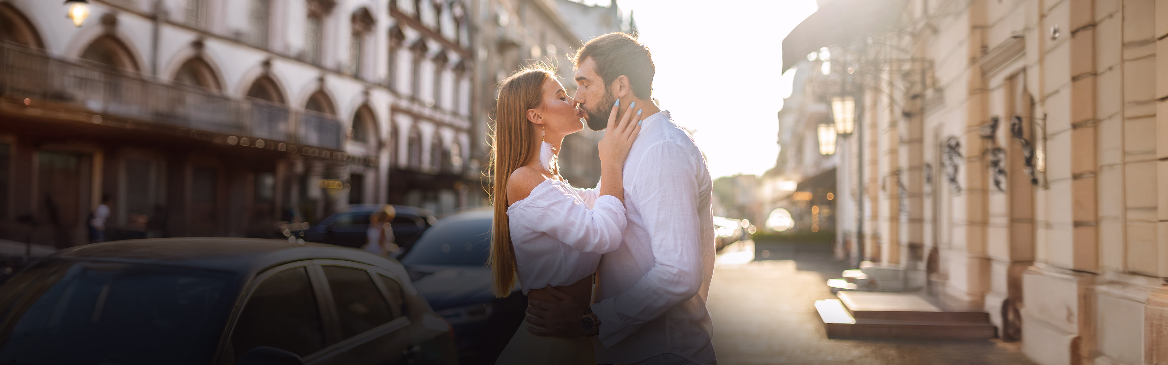 Couple s’embrassant dans une rue baignée de lumière, symbole d’amour et de lien affectif